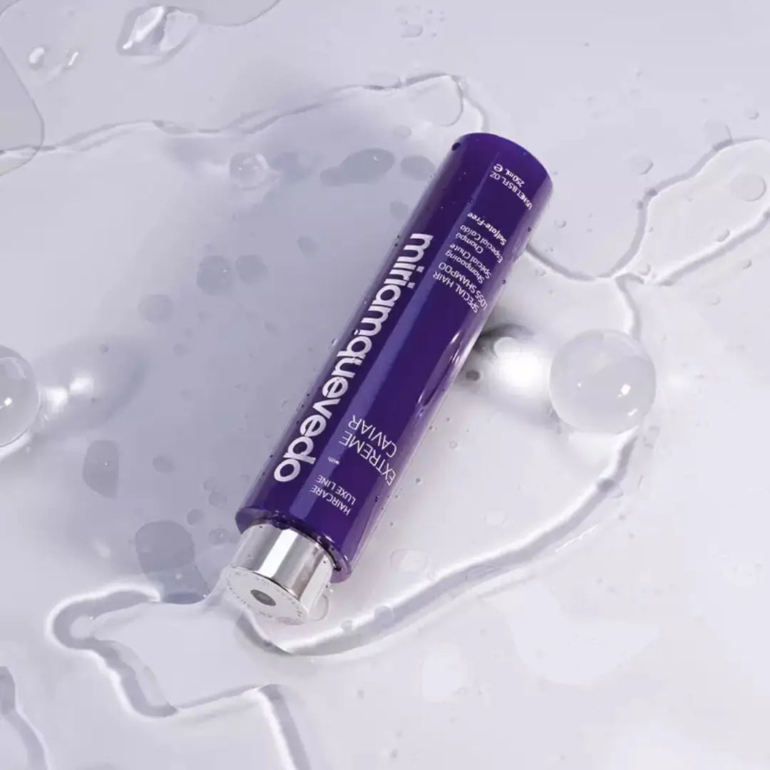 MiriamQuevedo Extreme Caviar Special Hair Loss Shampoo 250ml, deep blue bottle with silver cap, lying on wet surface, luxurious hair revitalizing.